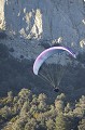 Le soleil va bientôt disparaître derrière l'horizon et les courants ascendants sont moins efficaces. Ce parapente prépare son atterrissage au bas de la falaise de Peyrepertuse. aude,chateaux cathares,peyrepertuse,cucugnan,parapente 